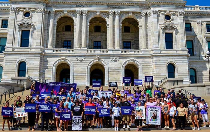 Large crowd of activists holding signs about the fentanyl crisis at the Minnesota state capitol